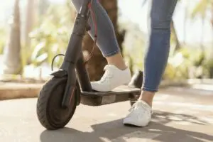 Person riding an e-scooter on Sacramento sidewalk