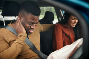 african-american-man-holding-neck-in-car-with-woman