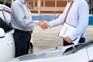 two-guys-shaking-hands-insurance-paperwork