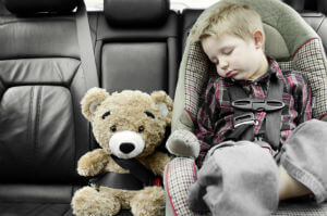 child in carseat with bear