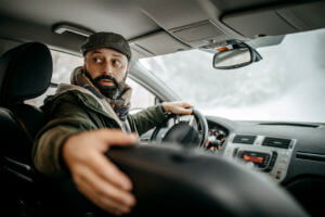 man-with-hat-coat-beard-driving-reverse