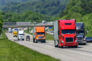 several trucks rolling down highway