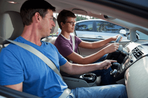Father teaching his teenaged son to drive