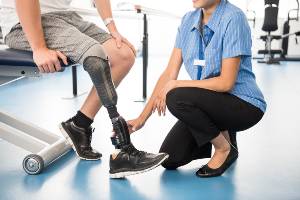physical therapist with man with prosthetic leg