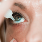 Woman putting eye drops in her eye