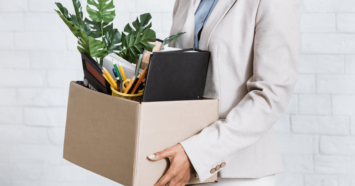 employee carting off with desk supplies in a box