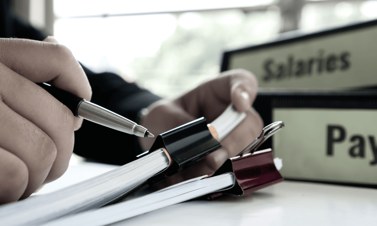 Stack of paper work flanked by folders that read 