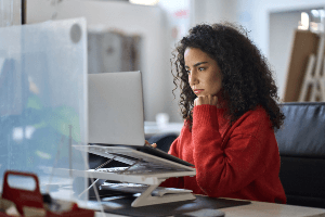 Woman staring intently at computer screen. 