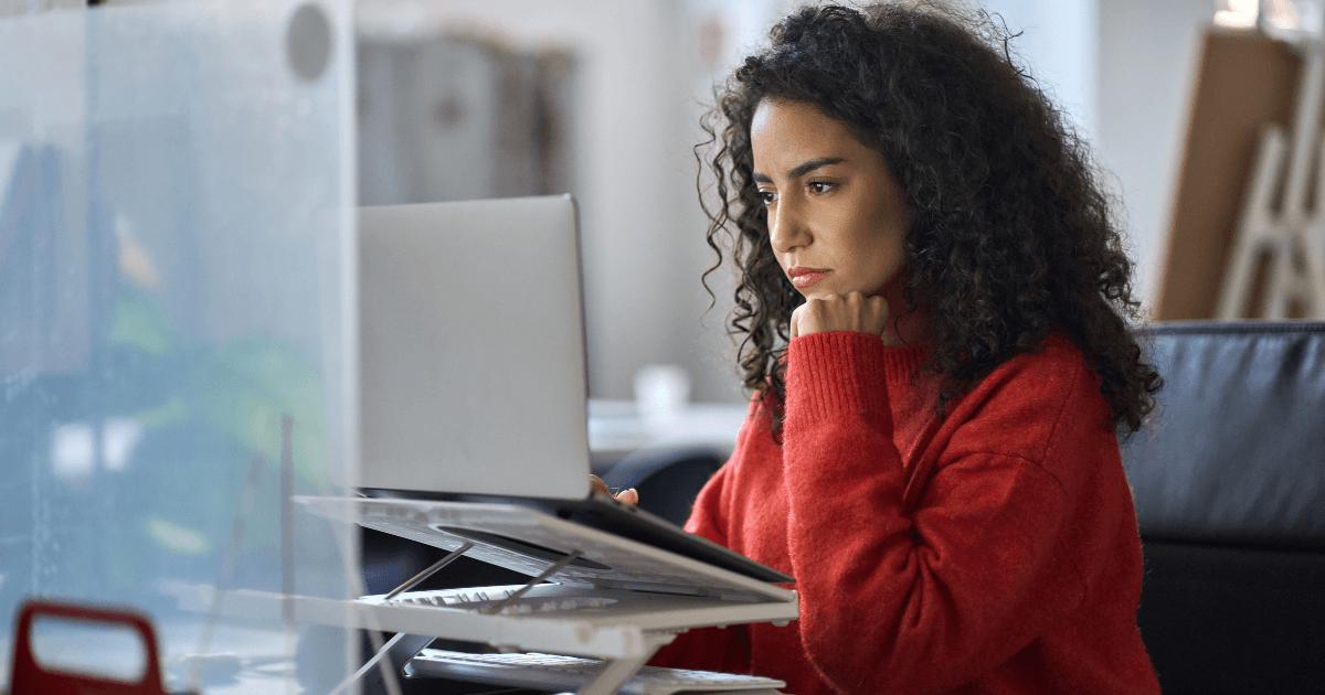 Woman staring intently at computer screen.