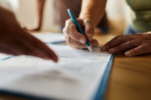 close-up stock image of a hand signing a document