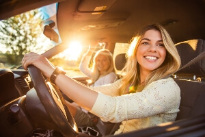 female teen driver in car with mom on a sunny day in California