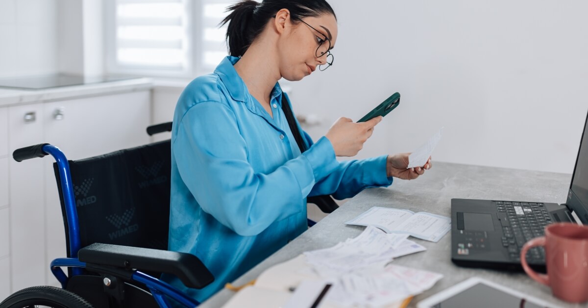 woman in wheelchair inputting expenses to her computer