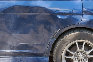 close-up image of the dented in side of a car caused by a T-bone crash.