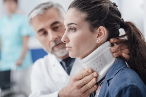 close-up of doctor putting a neck brace on a young female crash victim