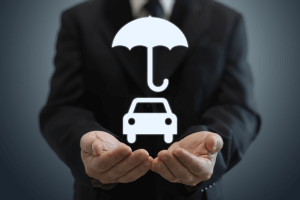 man cupping his hands to hold a car and an umbrella 