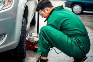 mechanic-green-overalls-changing-tire