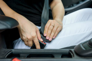 woman-hands-with-white-pants-clicking-seat-belt